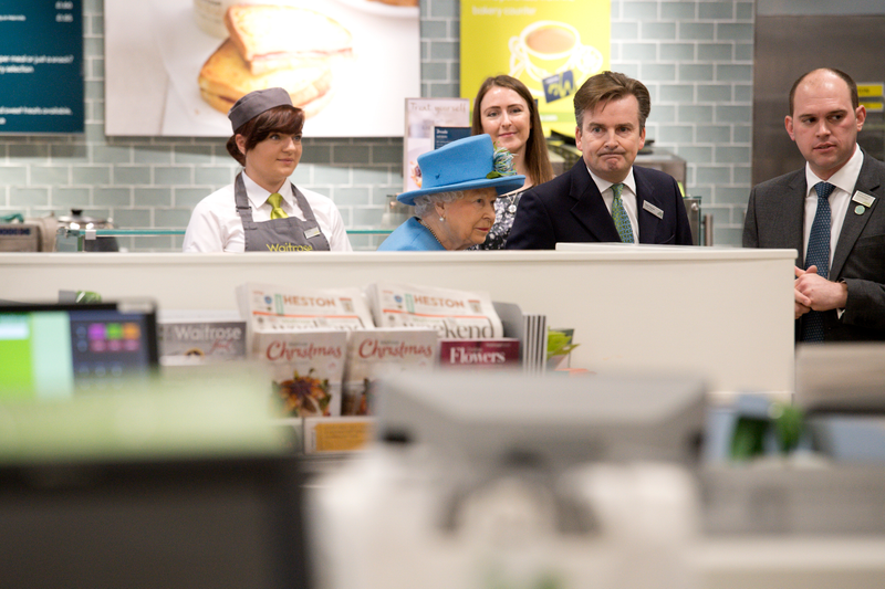 Britain’s Queen Elizabeth II (C) visits a Waitrose supermarket in the town on October 27, 2016 in Poundbury, England. Photo via Getty Images.